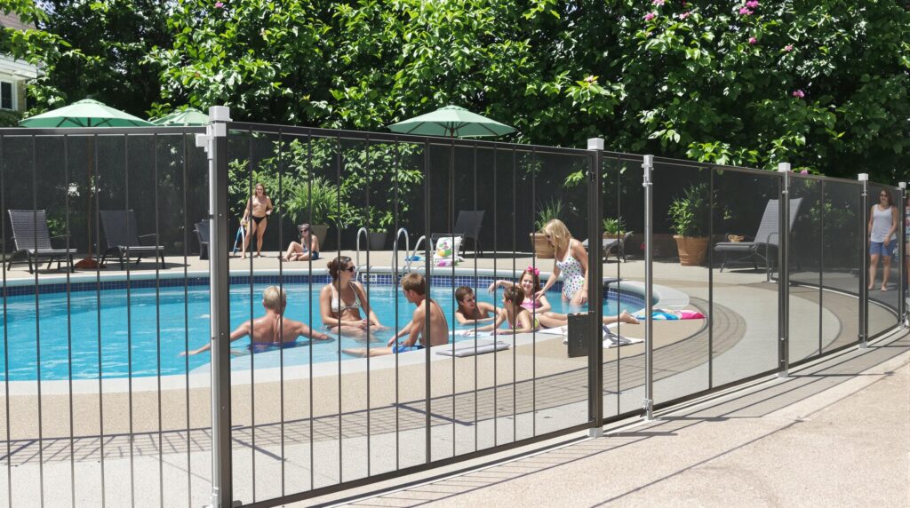 People enjoying a pool surrounded by a safety fence.