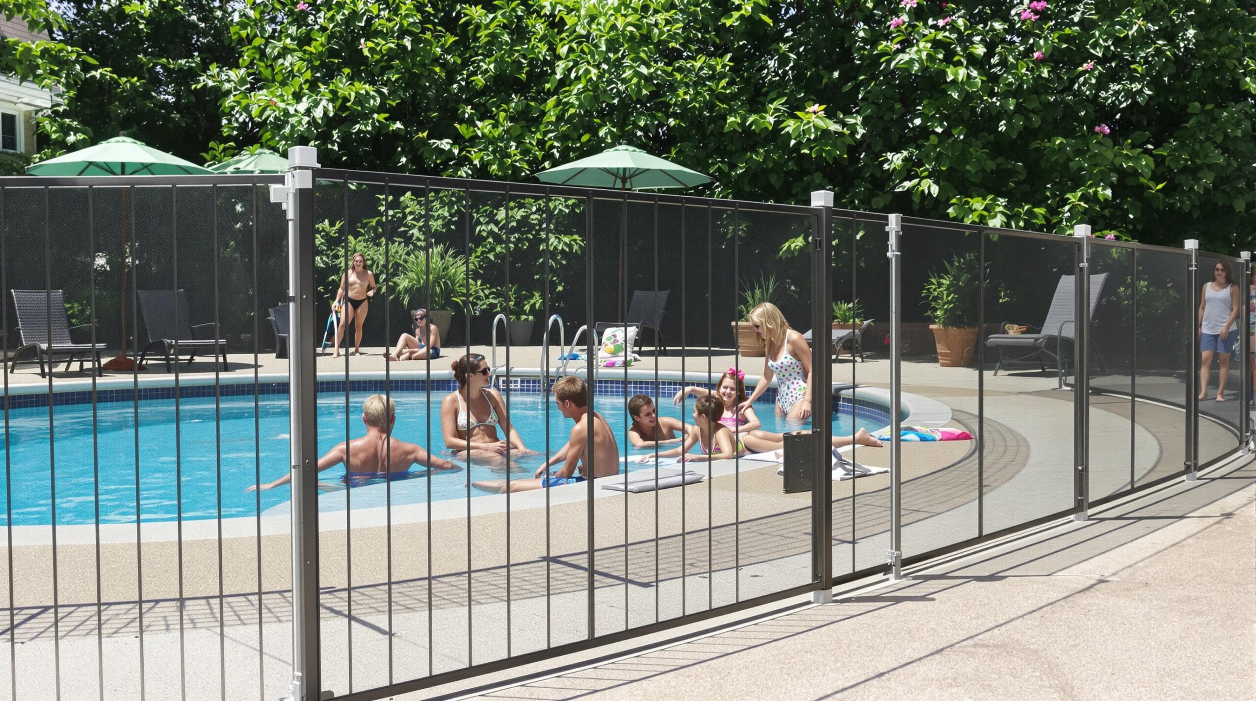 People enjoying a pool surrounded by a safety fence.