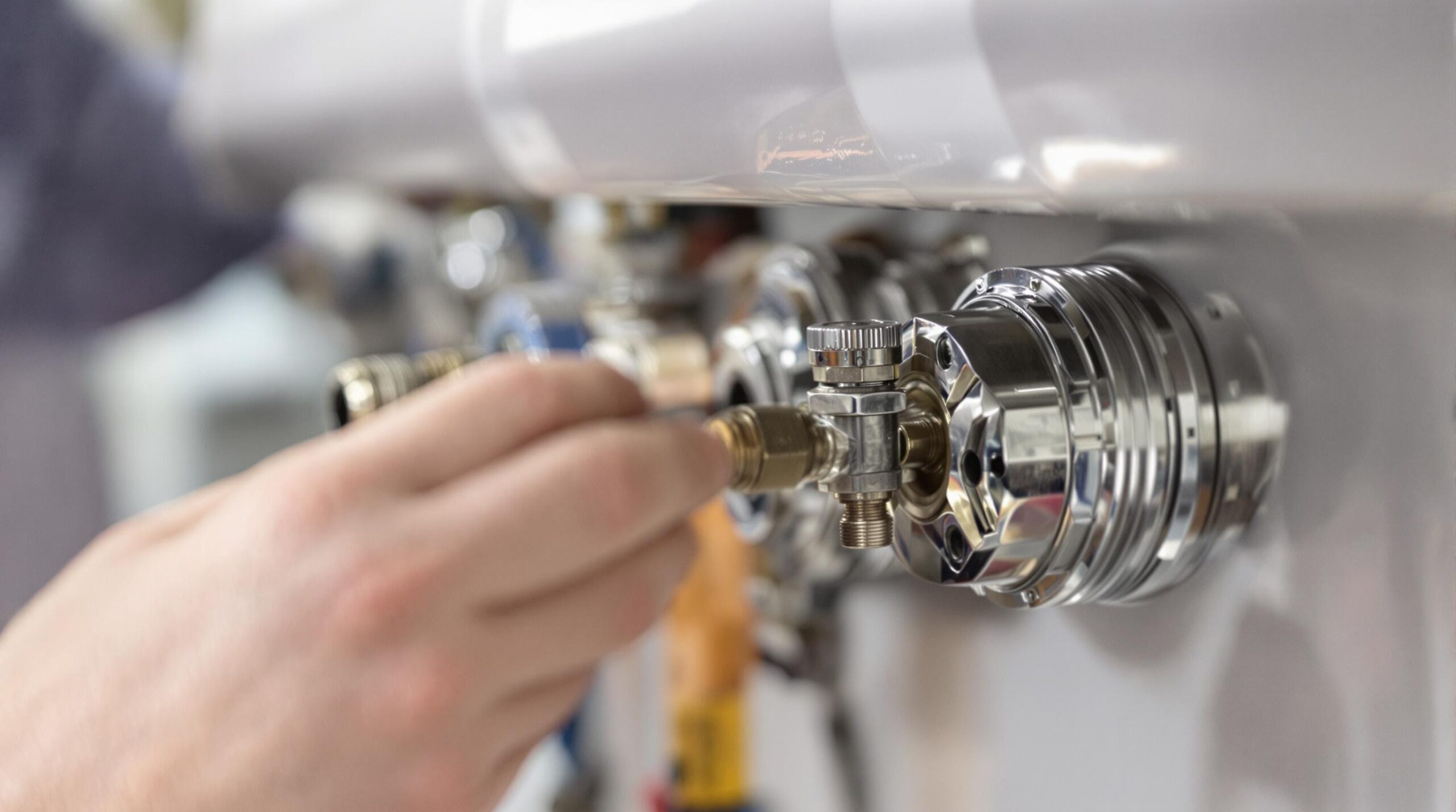 Hand adjusting a valve on a plumbing fixture.